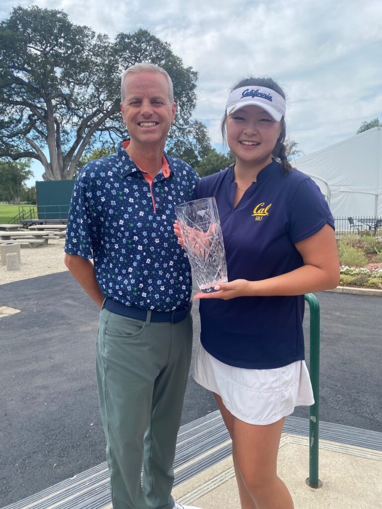 Kaylyn Noh and Mike Woods posing for the camera after Kaylyn's victory. Kaylyn is holding the glass trophy for the Sacramento Valley Women's Amateur Championship.