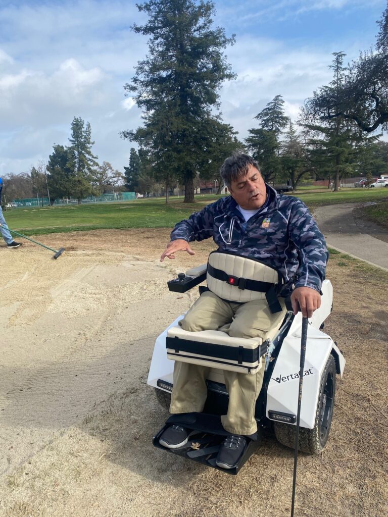 Golfer sitting in adaptive cart